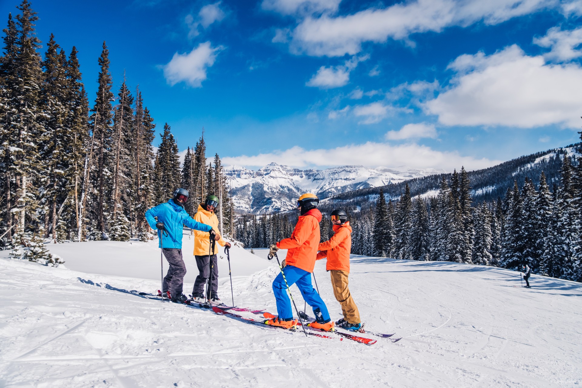 a group of people on skis on a snowy mountain with Winter Park Resort in the background