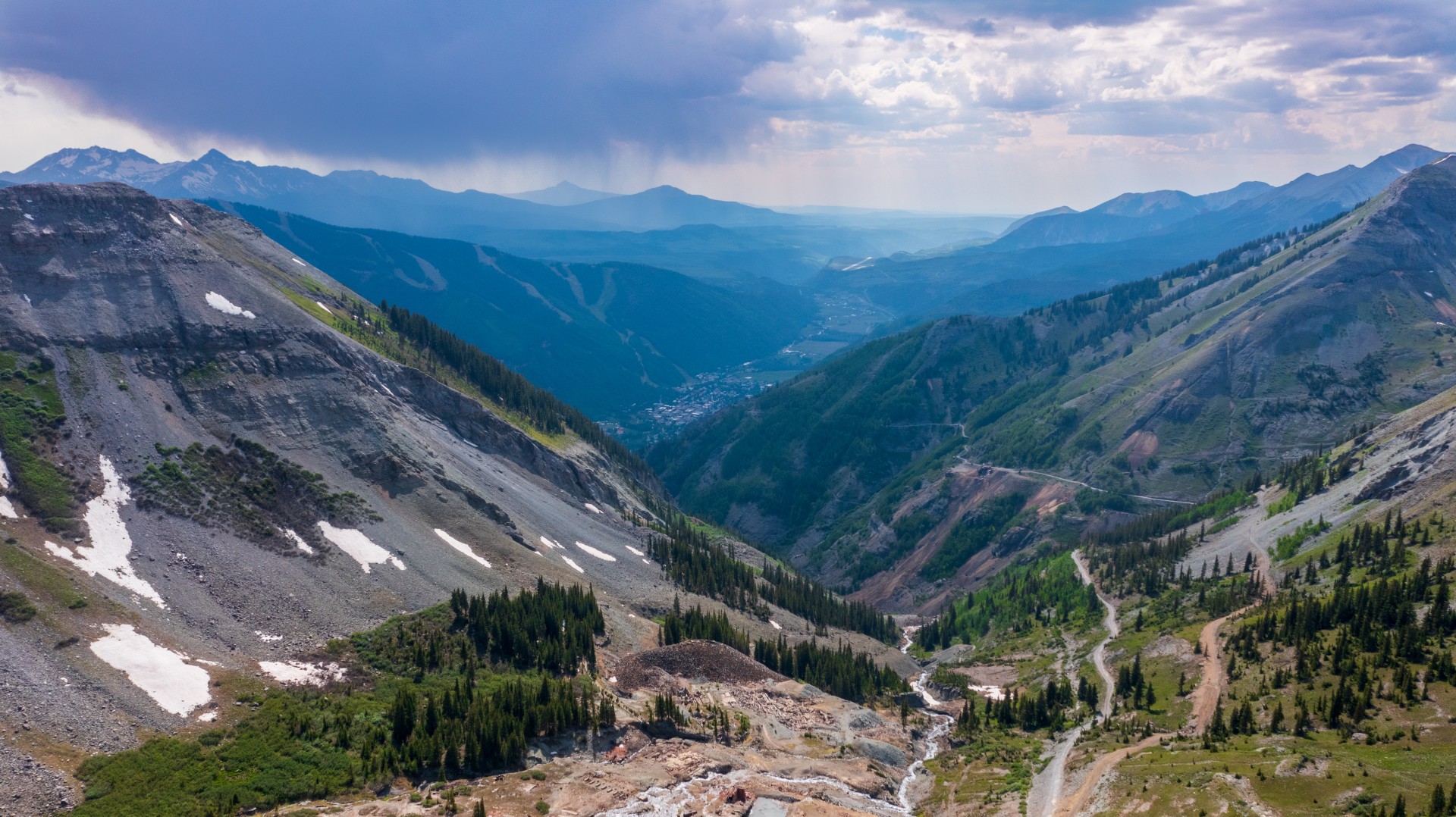 a mountain landscape with trees and a road