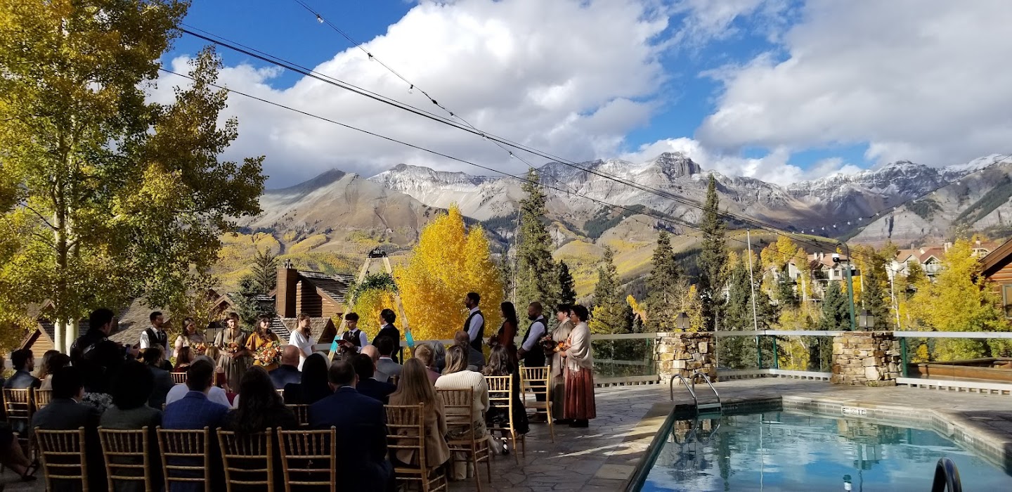 a group of people sitting in chairs outside by a pool