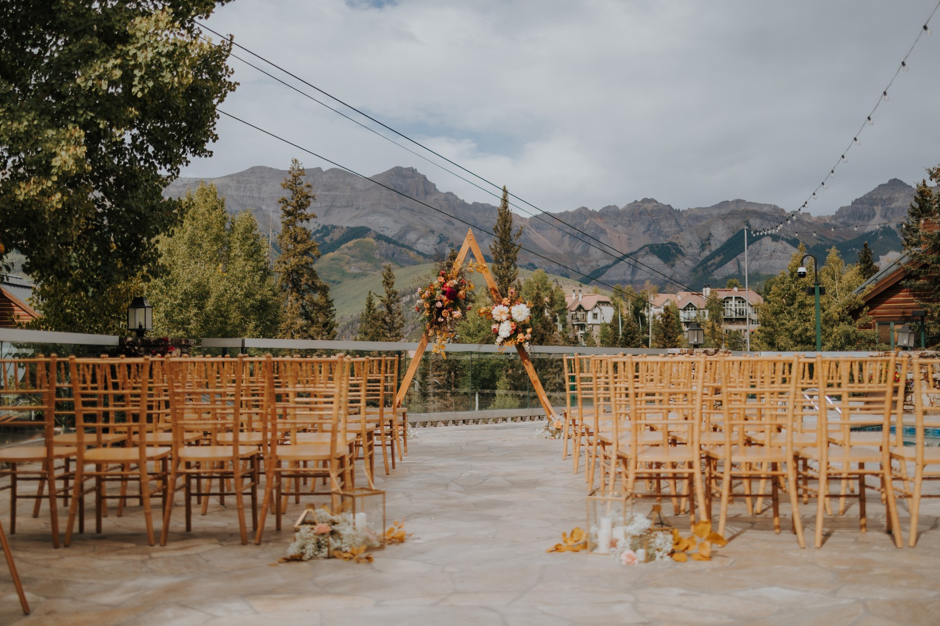 a group of chairs with flowers in front of mountains