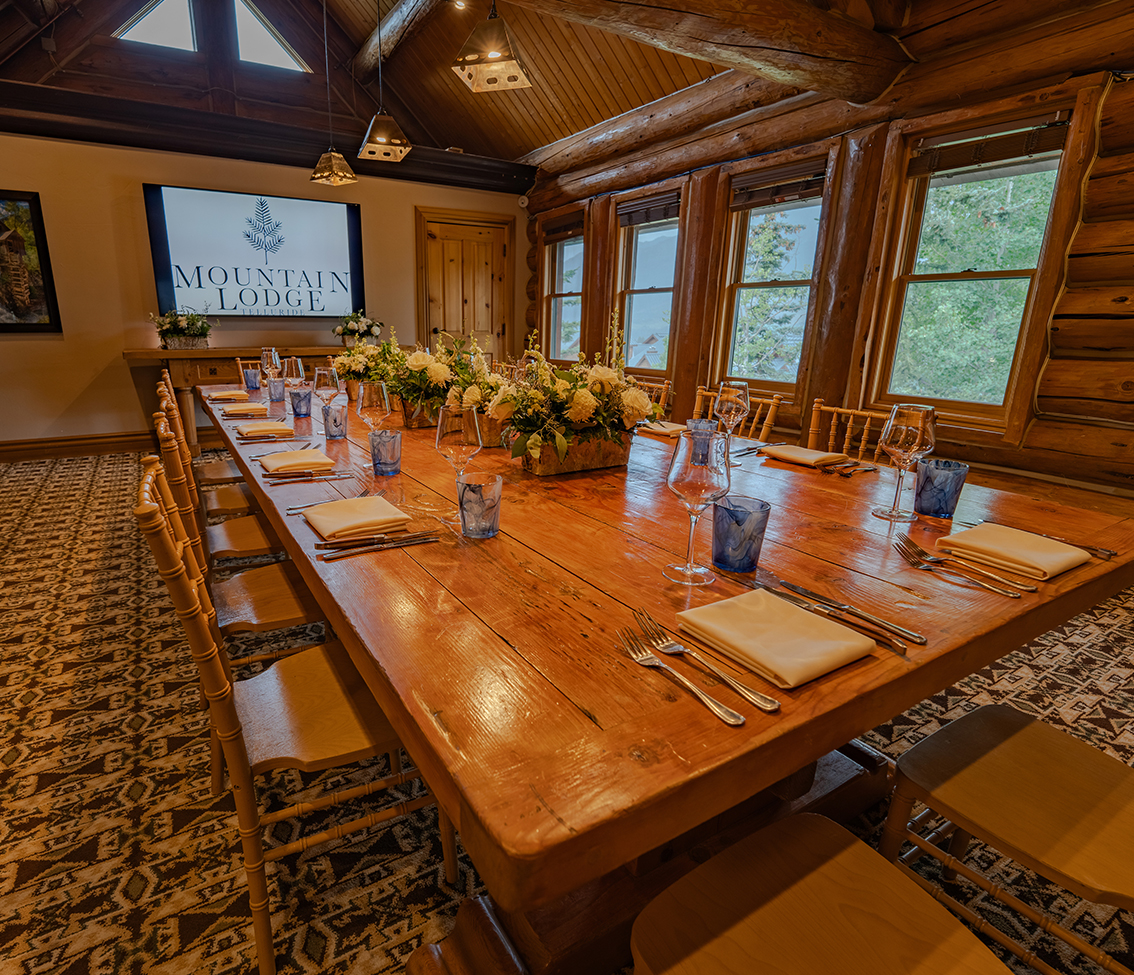 a dining table with a tv on the wall