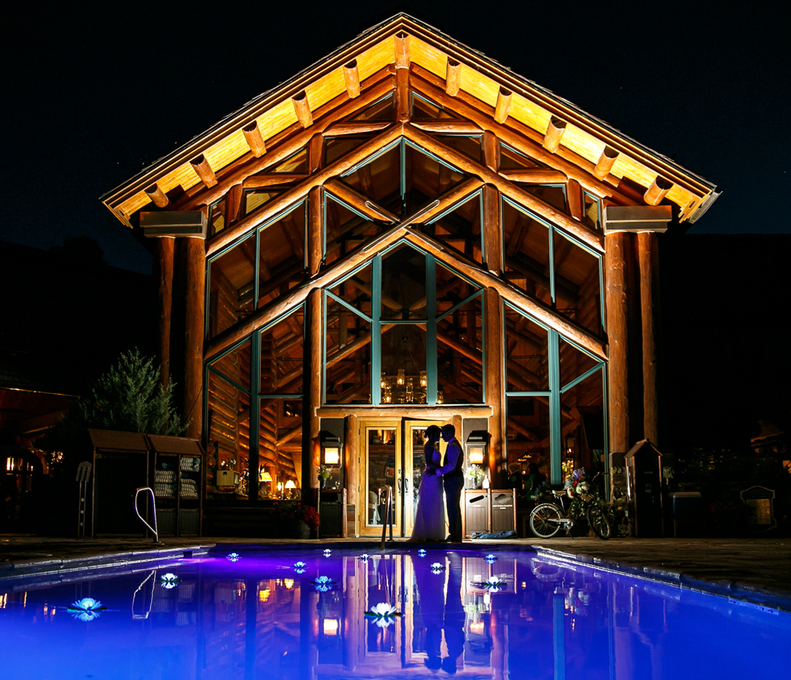 a man and woman standing in front of a house with a pool