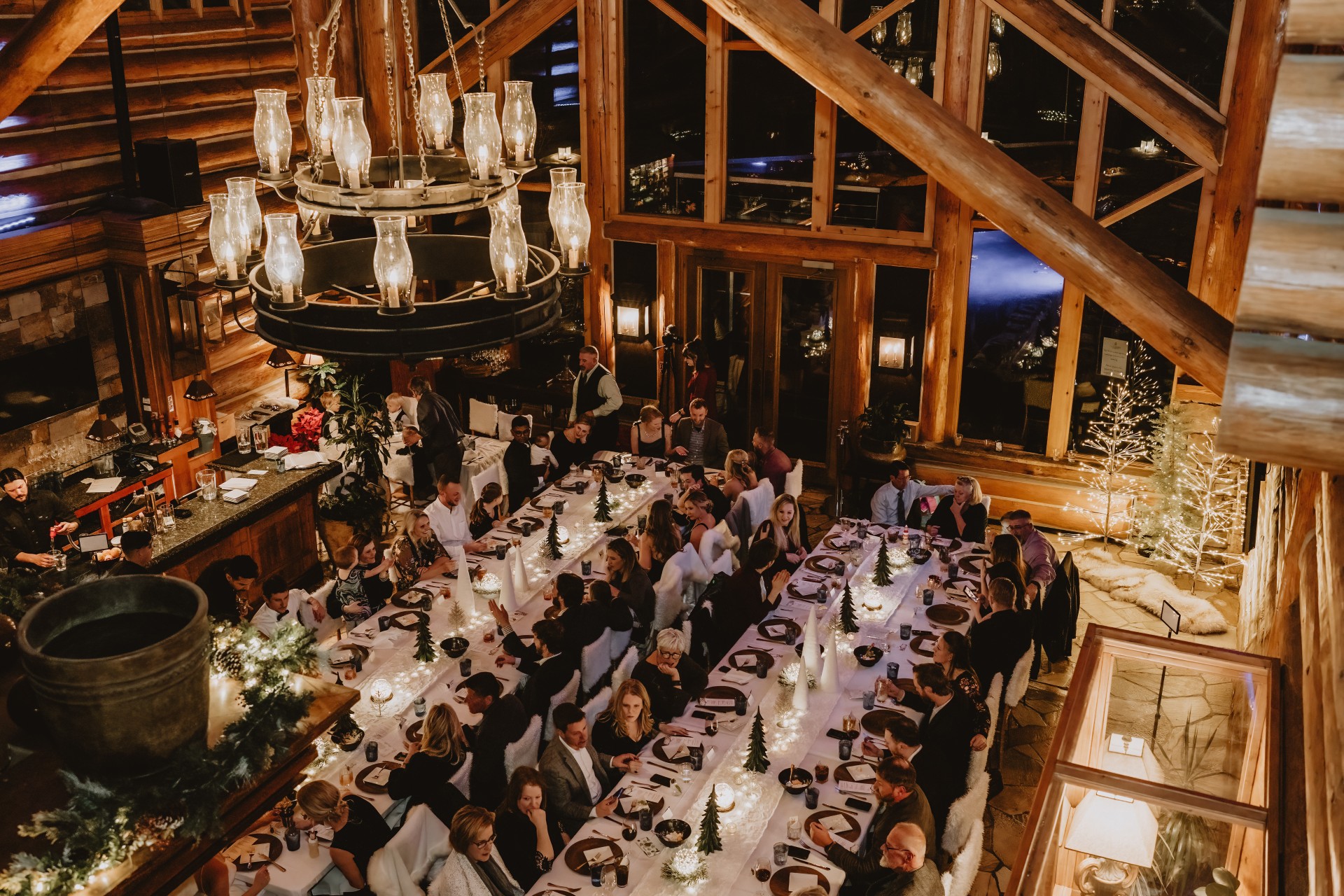 a group of people sitting at a table in a room with a chandelier