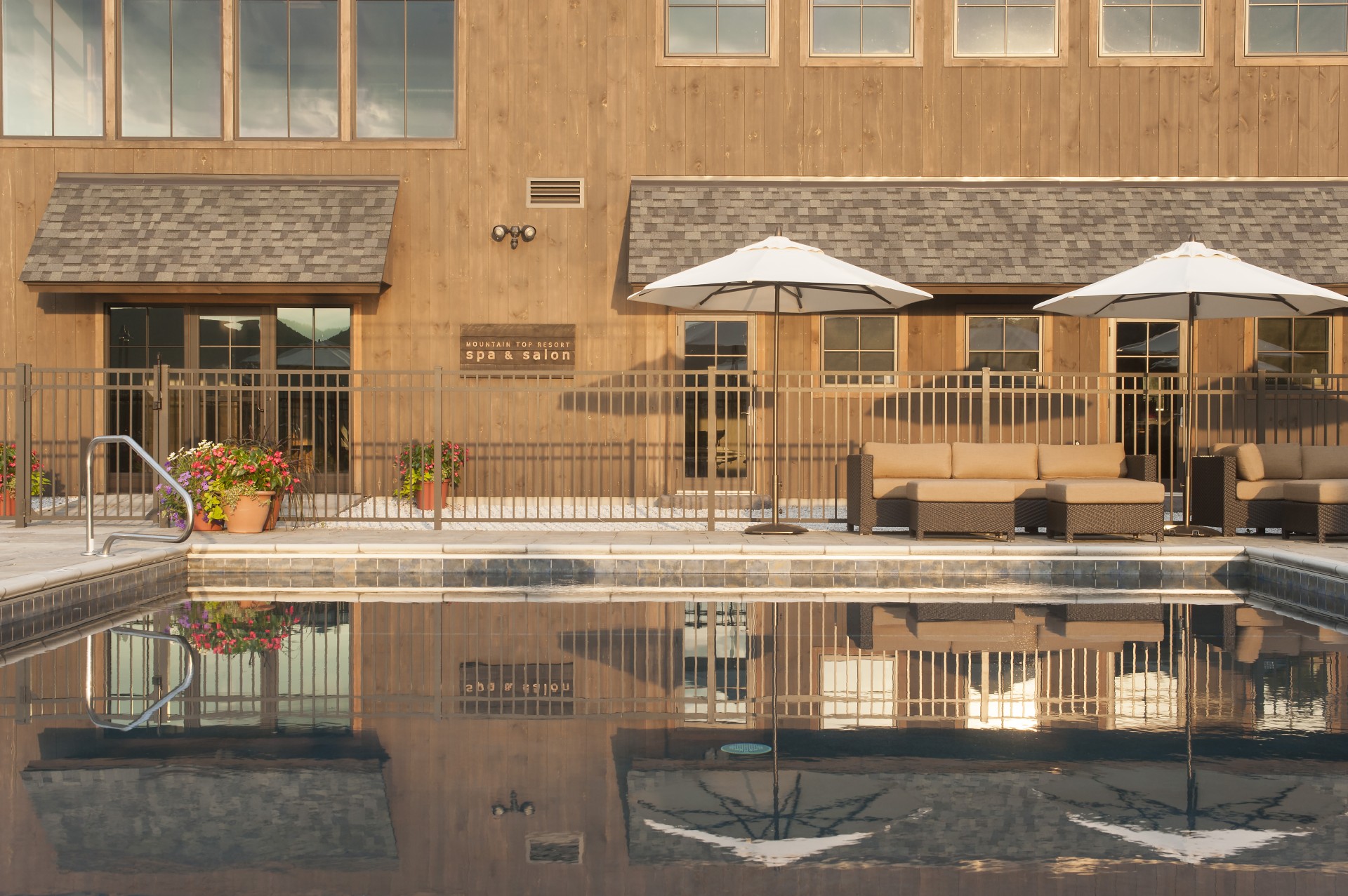 a pool with umbrellas and chairs in front of a building