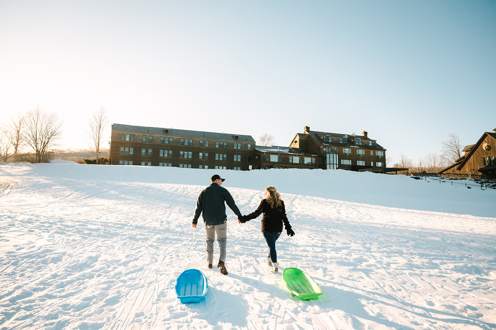 a man and woman holding hands in the snow