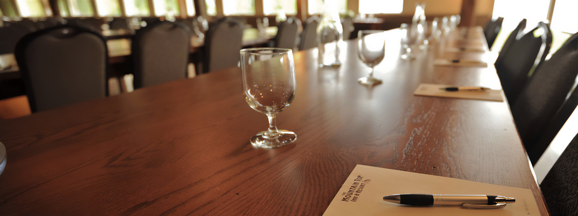 a table with a pen and a glass of wine on it