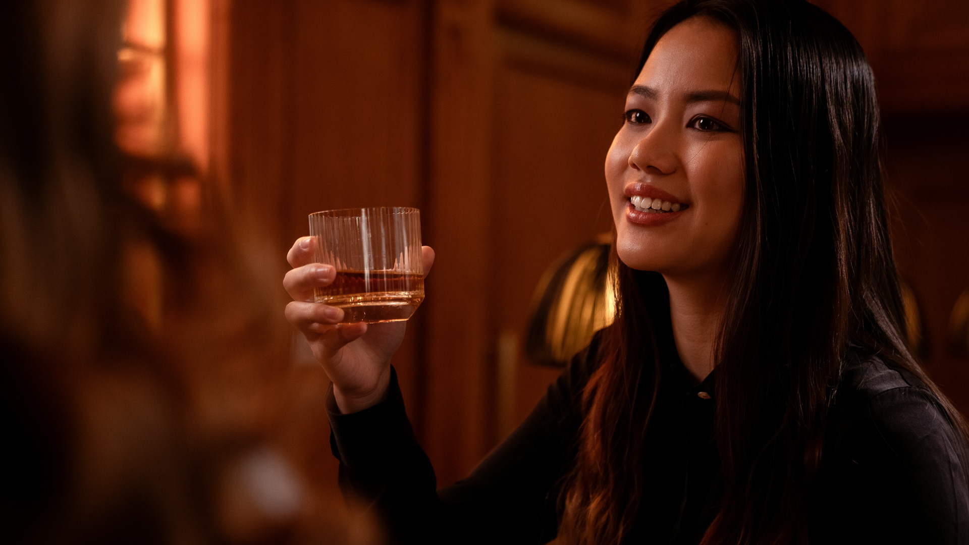 a woman holding a glass of liquid