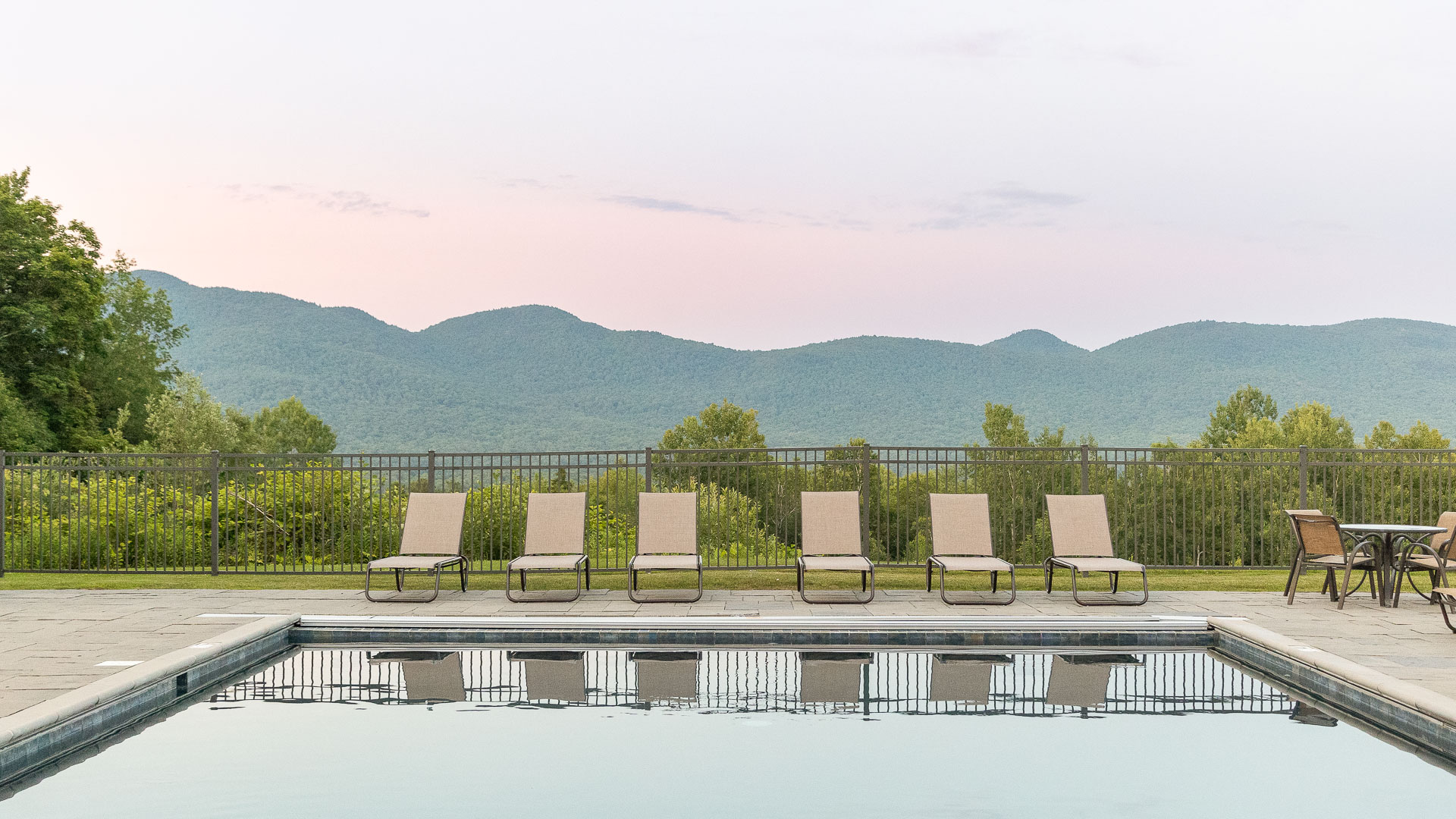 a pool with chairs and a fence