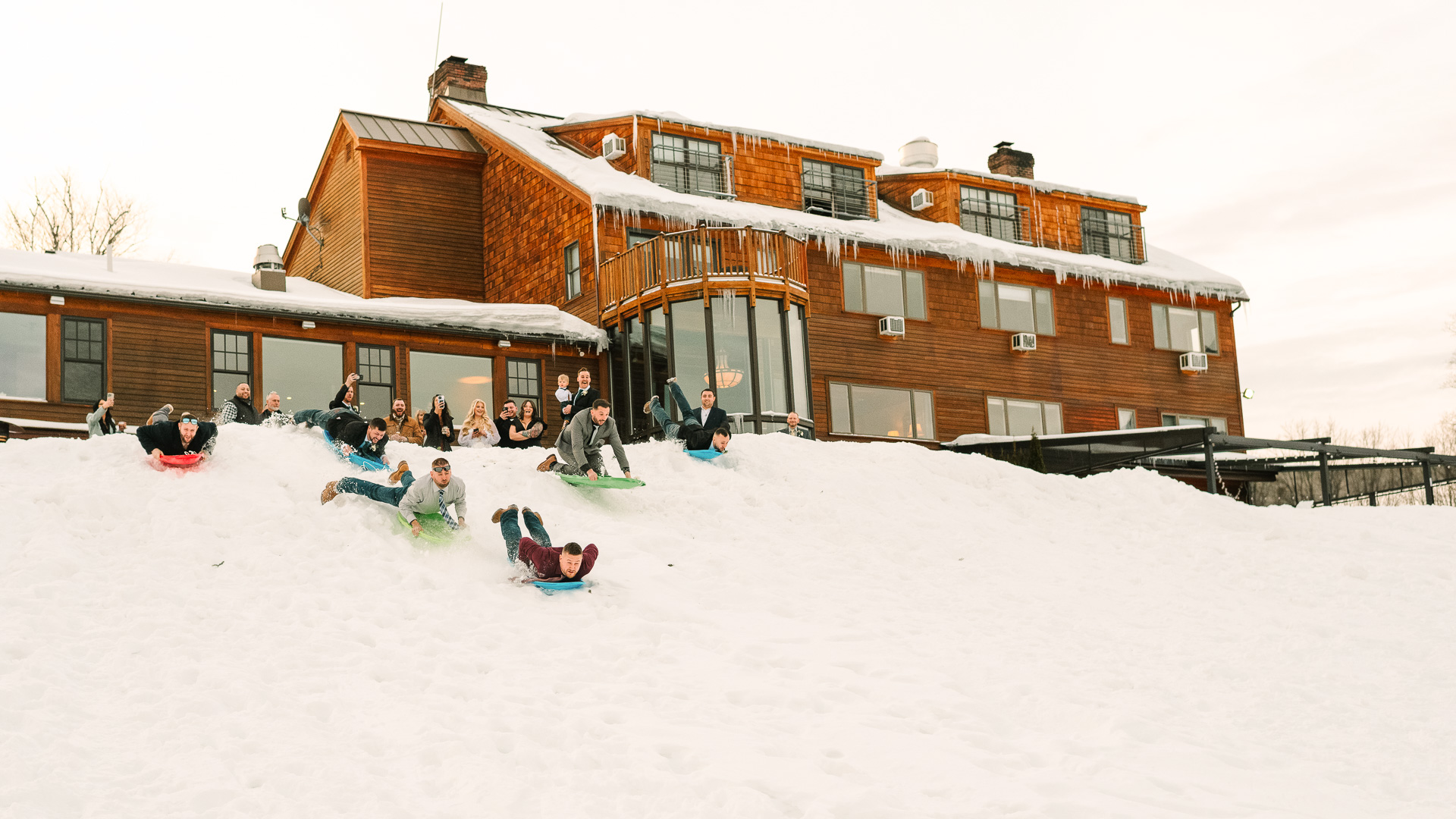 a group of people sledding down a hill in the snow