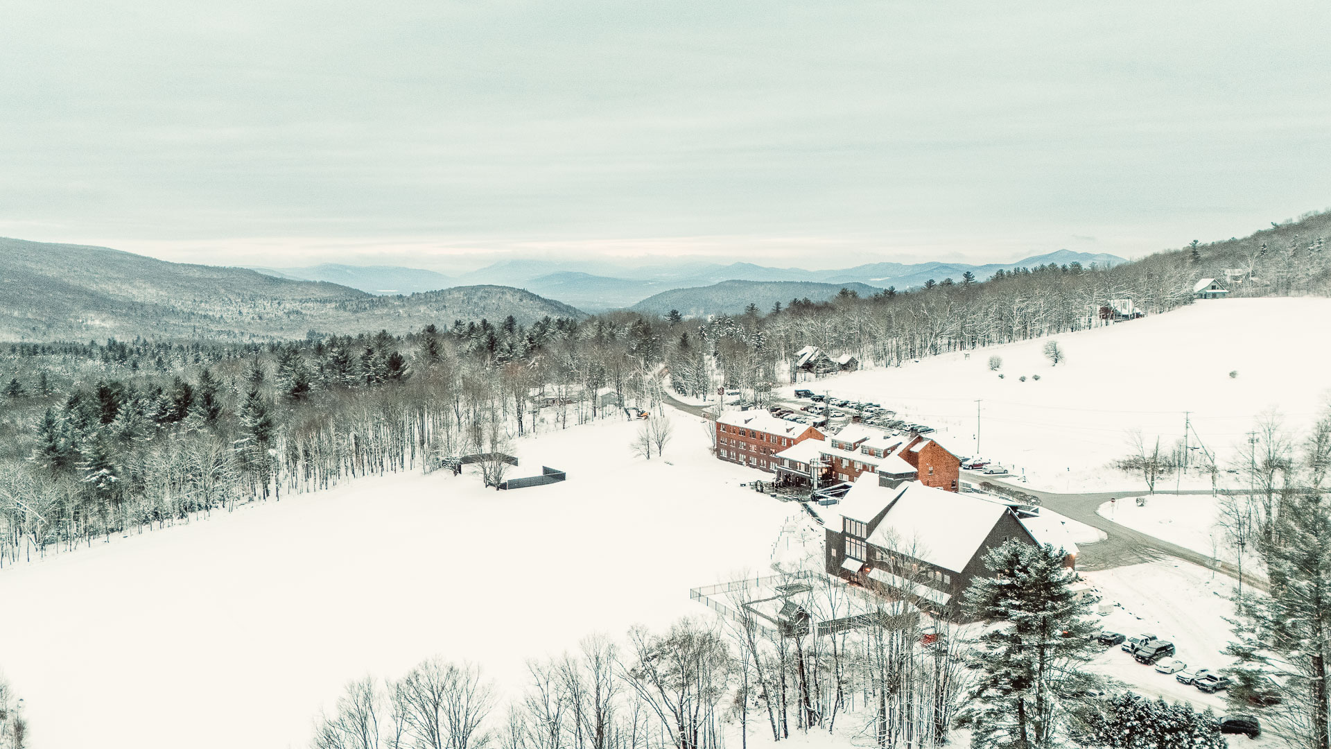 a snowy landscape with buildings and trees