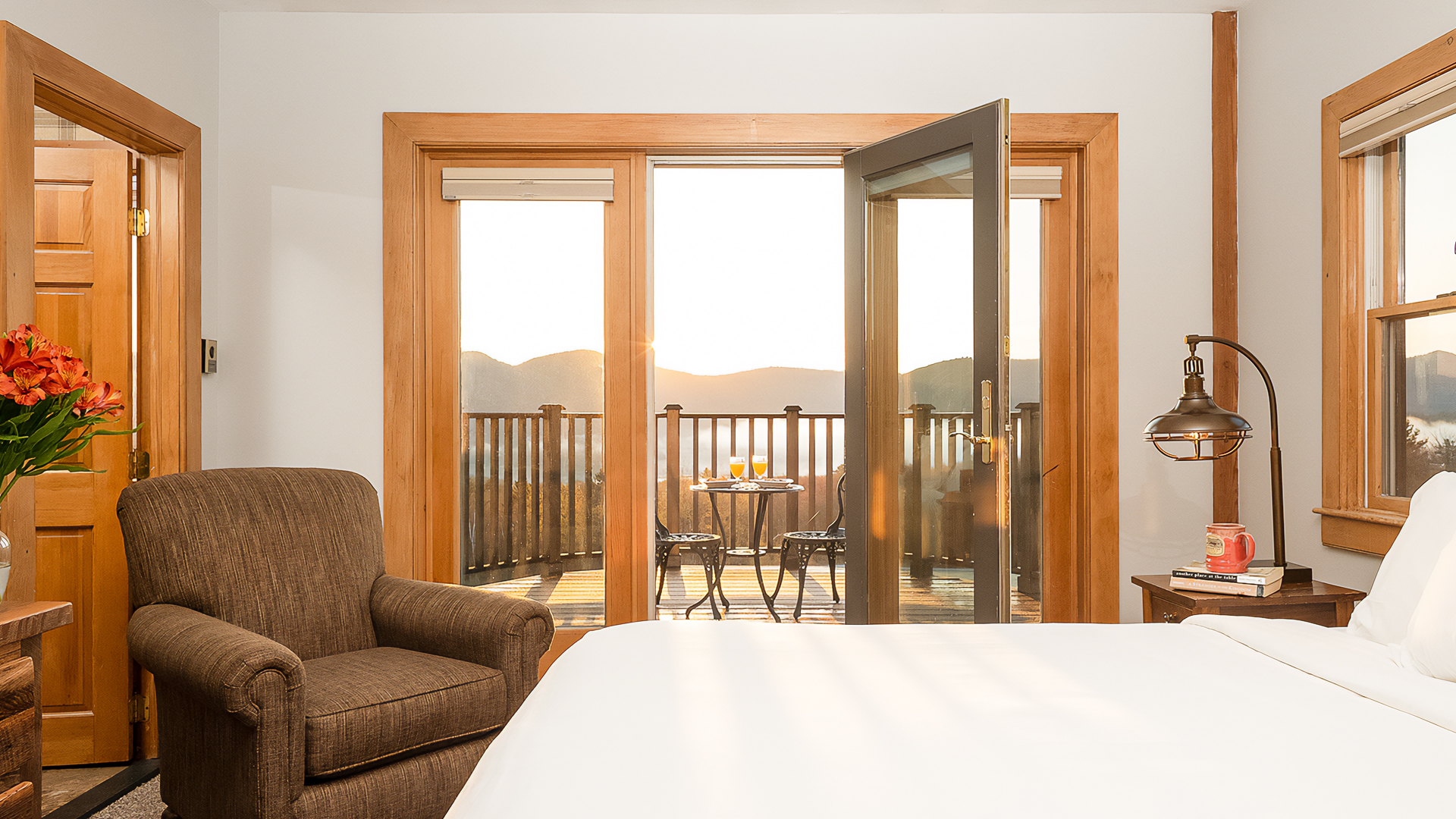 a room with a bed and a chair and a table with chairs outside