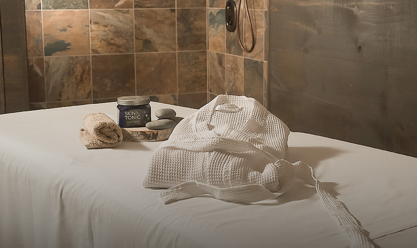 a white robe and a towel on a bed