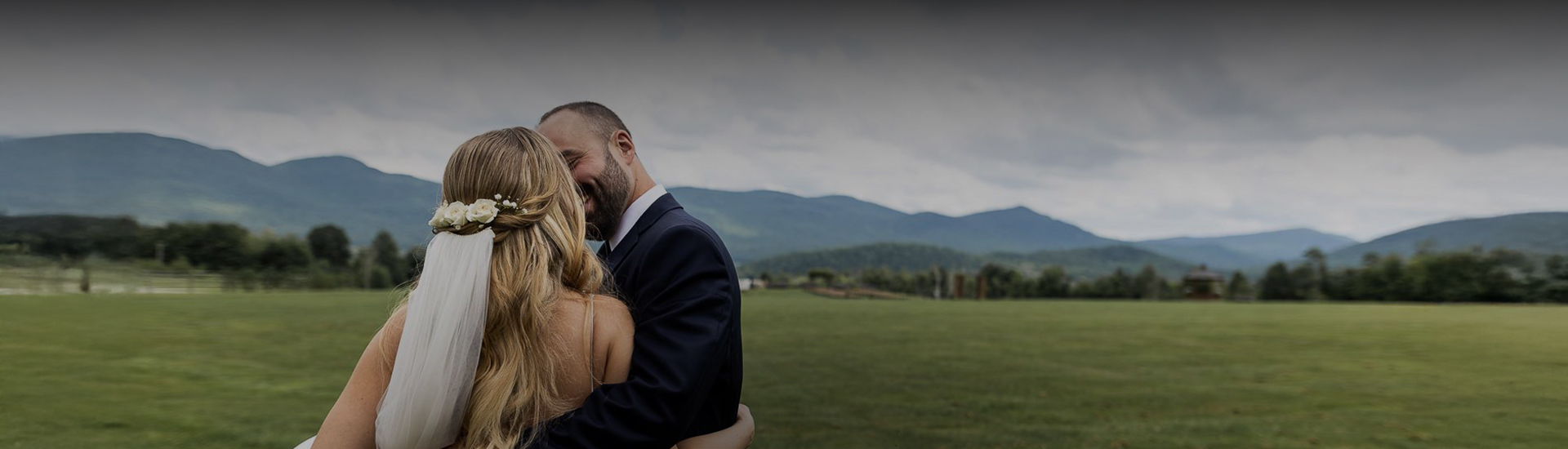 a man and woman hugging in front of a field