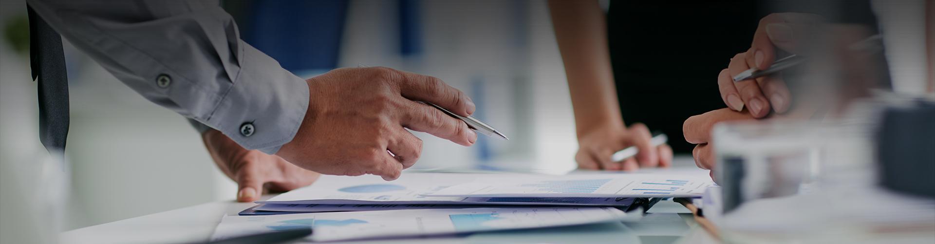 a person holding a pen over a paper