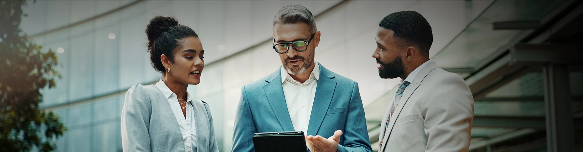 a man in a blue suit and glasses holding a tablet