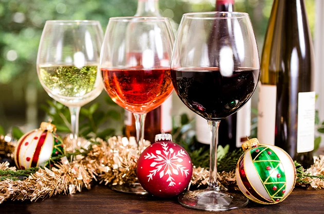 a group of wine glasses with ornaments and tinsel