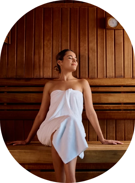 a woman sitting on a bench in a sauna