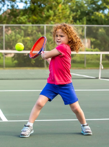 a girl swinging a tennis racket