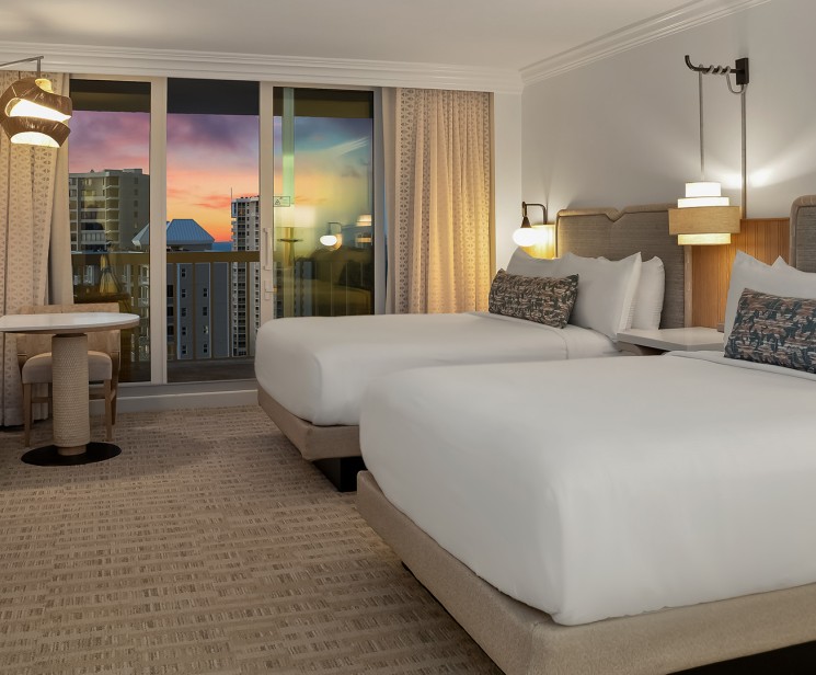 a hotel room with two beds and a table