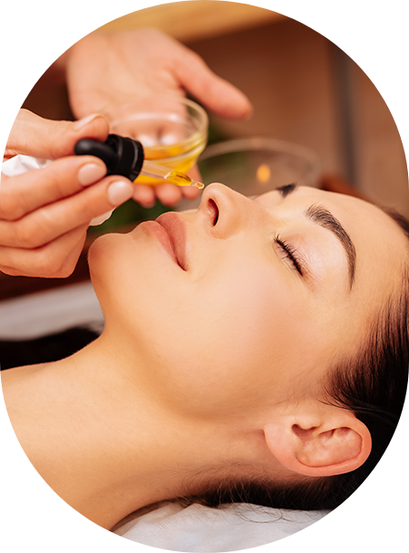 a woman receiving a facial oil