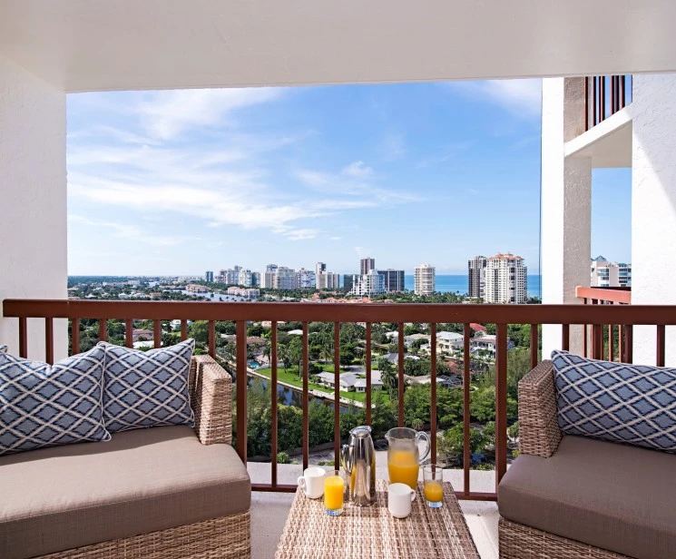 a balcony with chairs and drinks on it