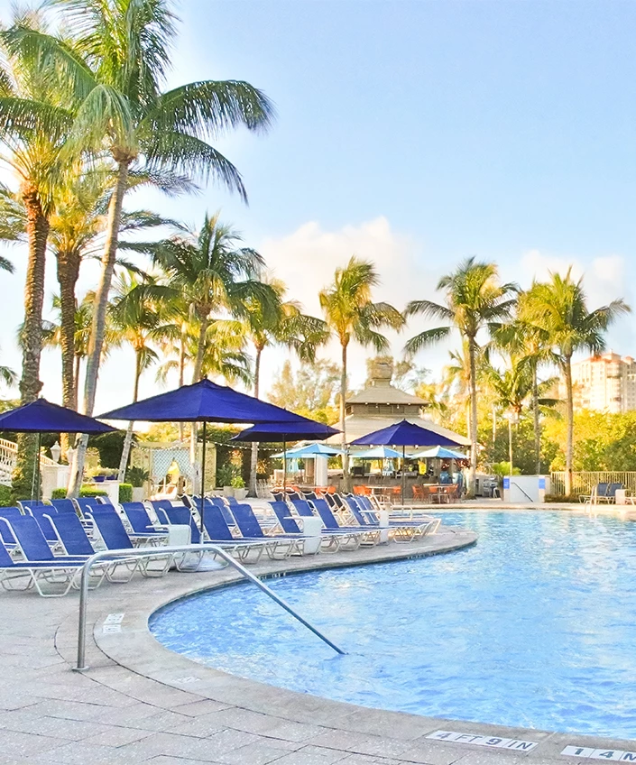 a pool with chairs and umbrellas