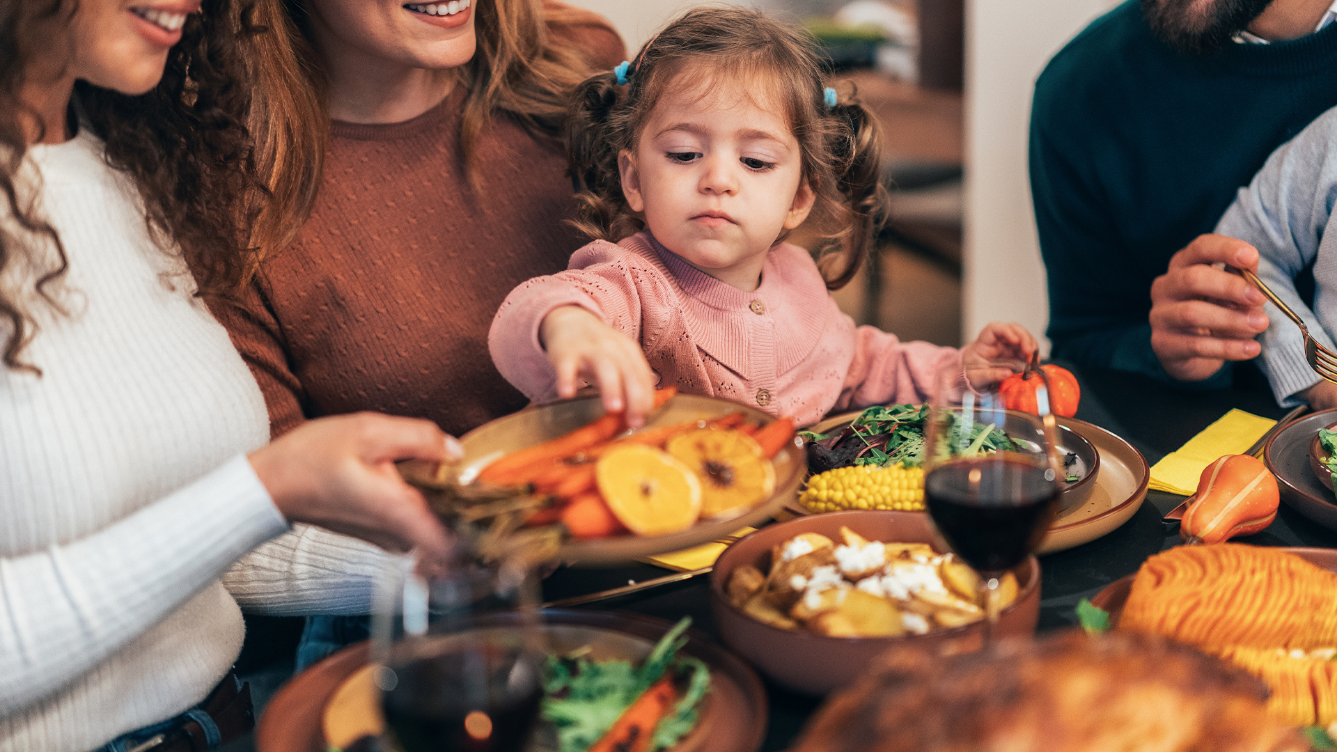 a woman and child at a table with food