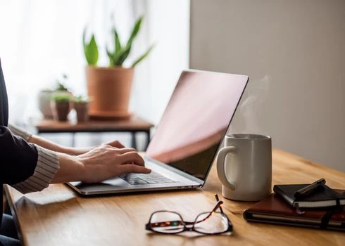laptop on table with coffee and glasses