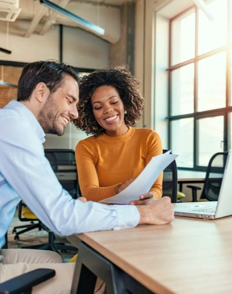 man and woman at a desk looking at papers