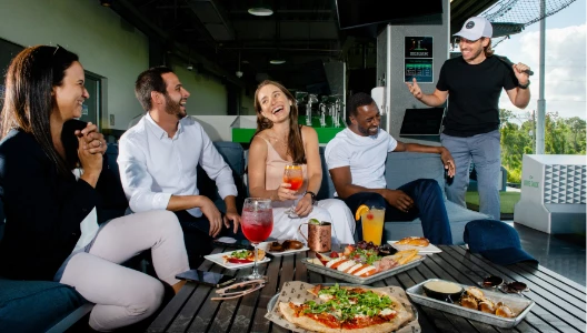 a group of people sitting around a table with food