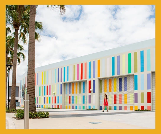 a woman walking in front of a colorful building