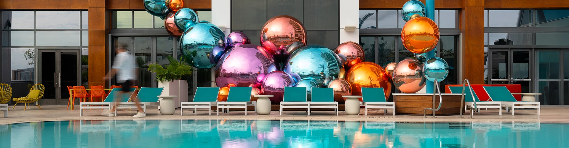 a pool with colorful balloons and chairs