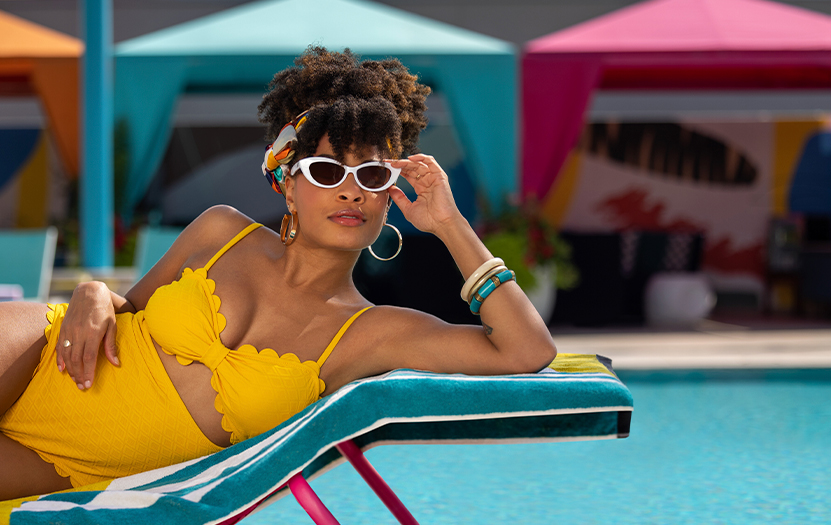 a woman in a yellow swimsuit and sunglasses