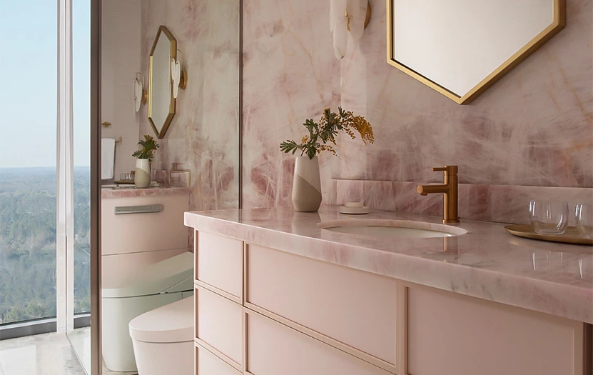 a bathroom with pink marble walls and a sink and mirror