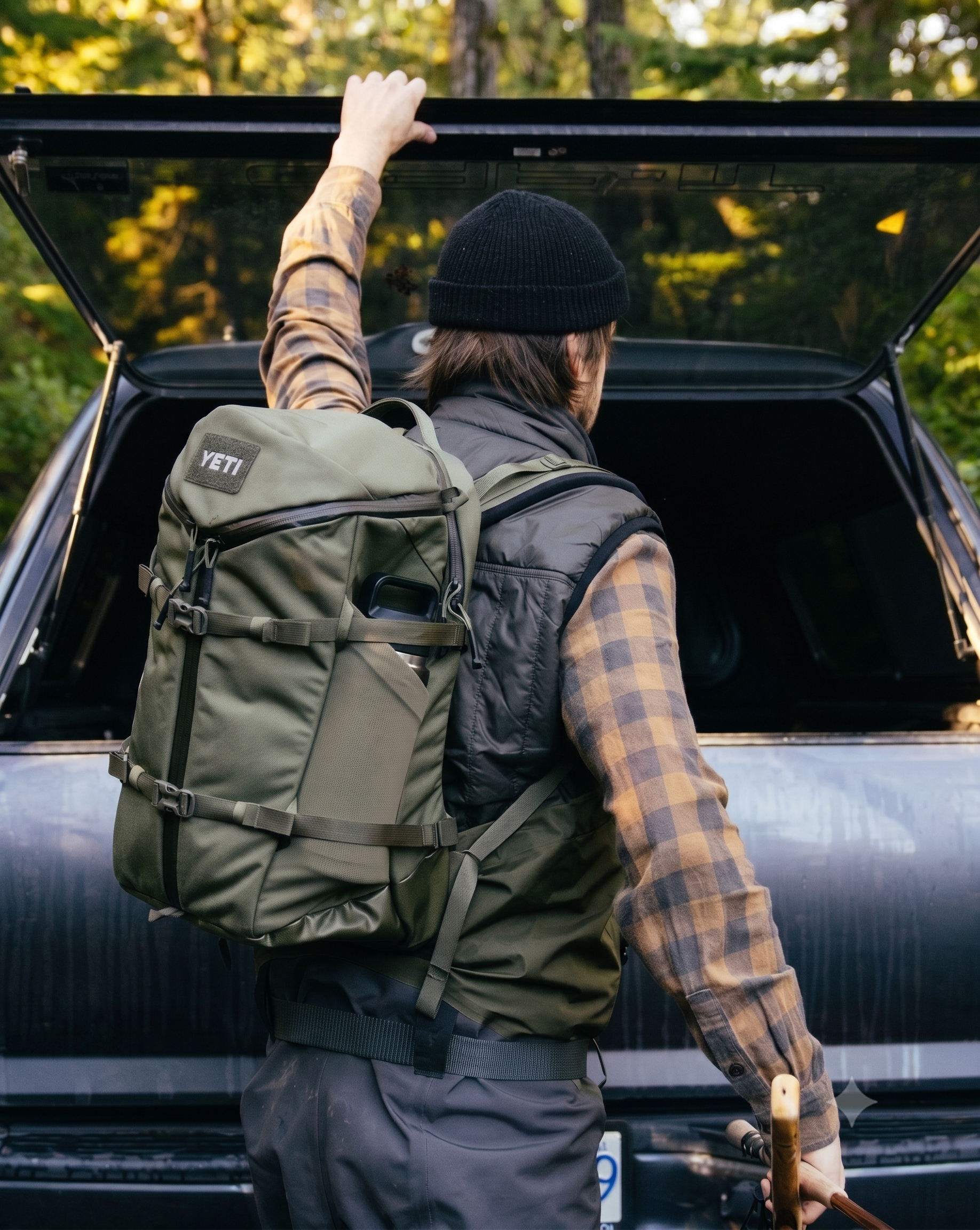 a man with a backpack standing in the back of a car