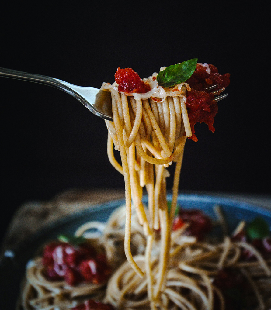 a fork with spaghetti and sauce on it