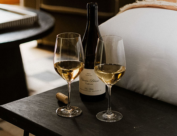 a bottle of wine and two wine glasses on a table