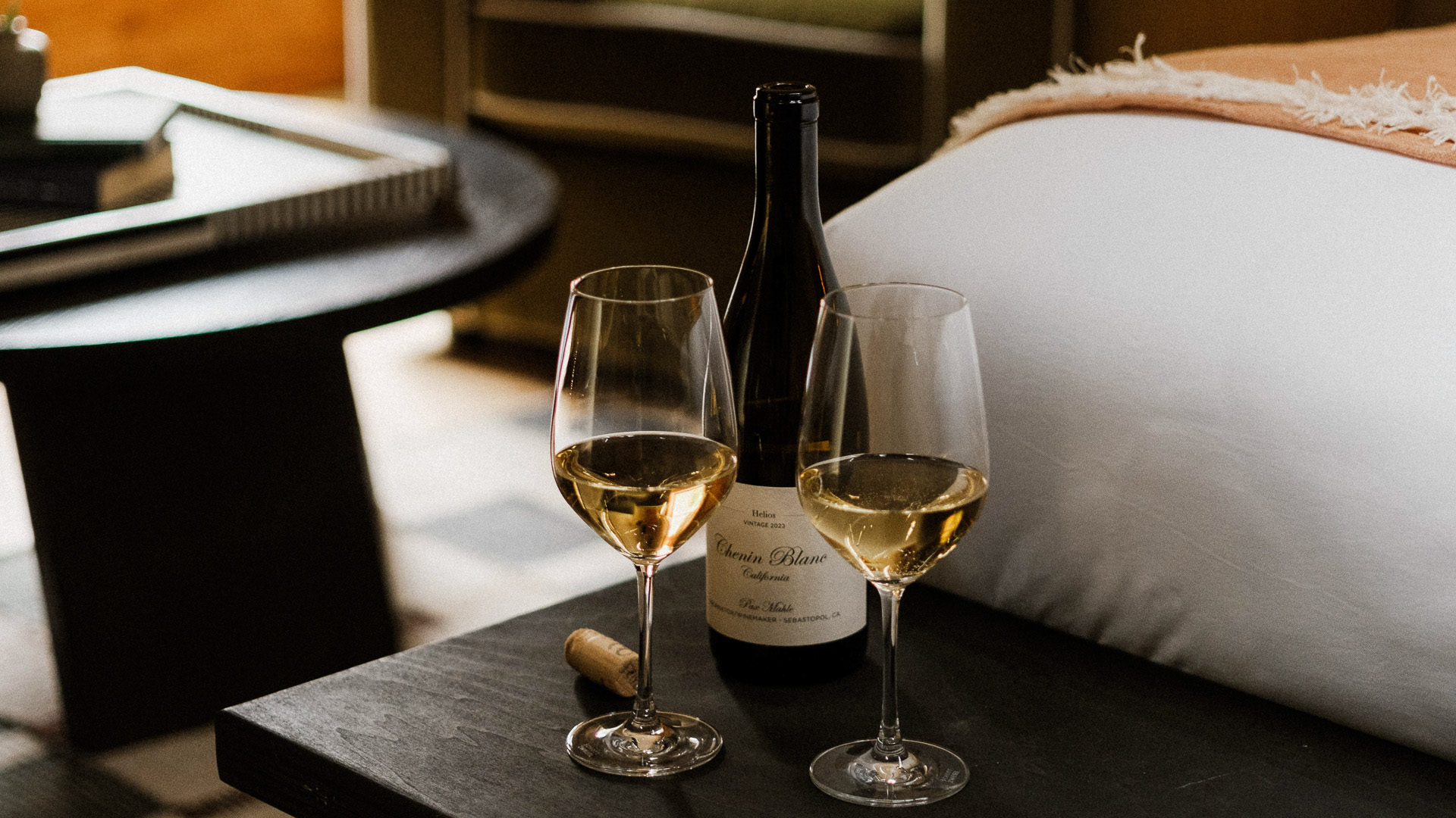 two glasses of wine and a bottle on a table