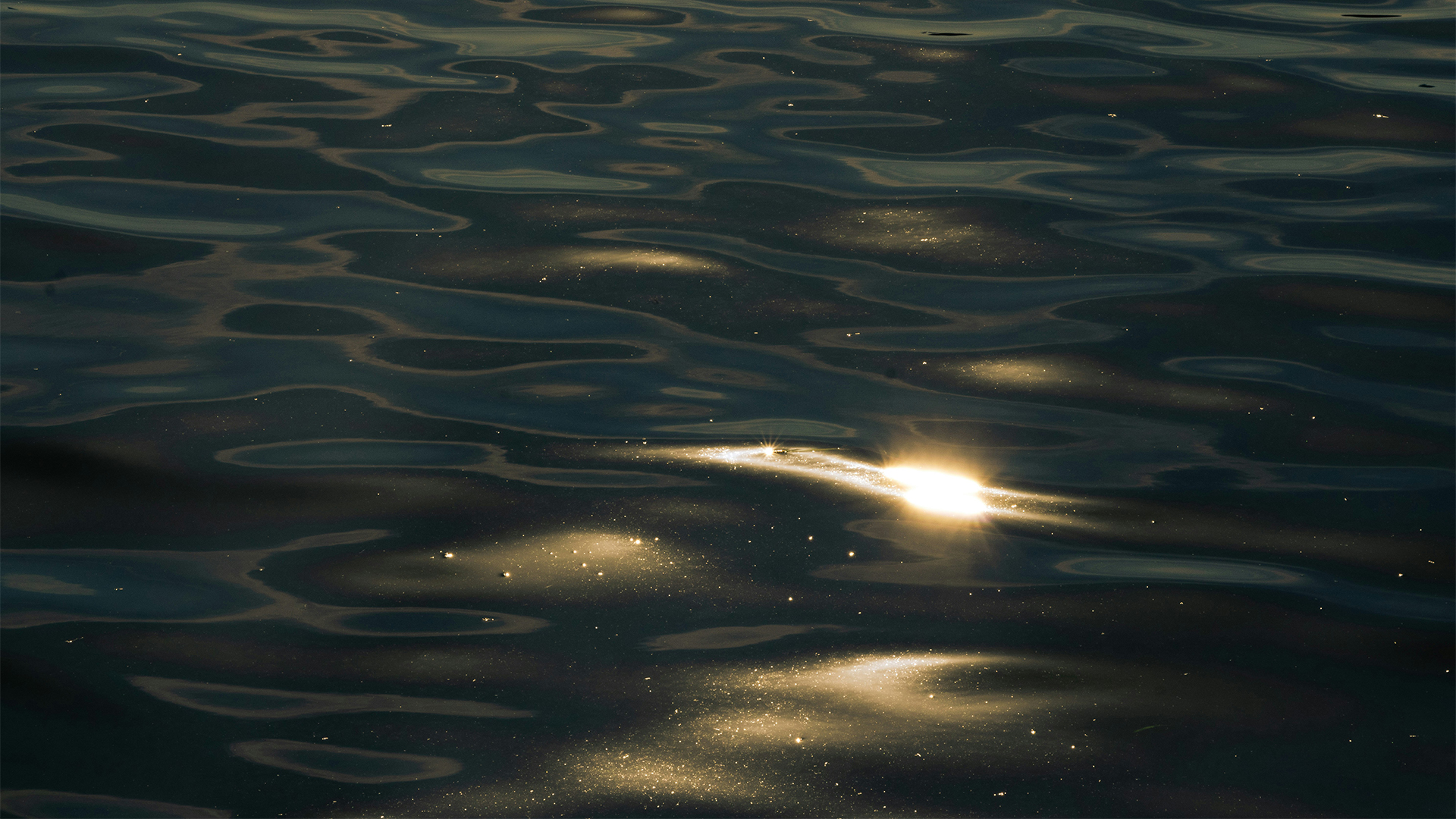 a sun shining on the water