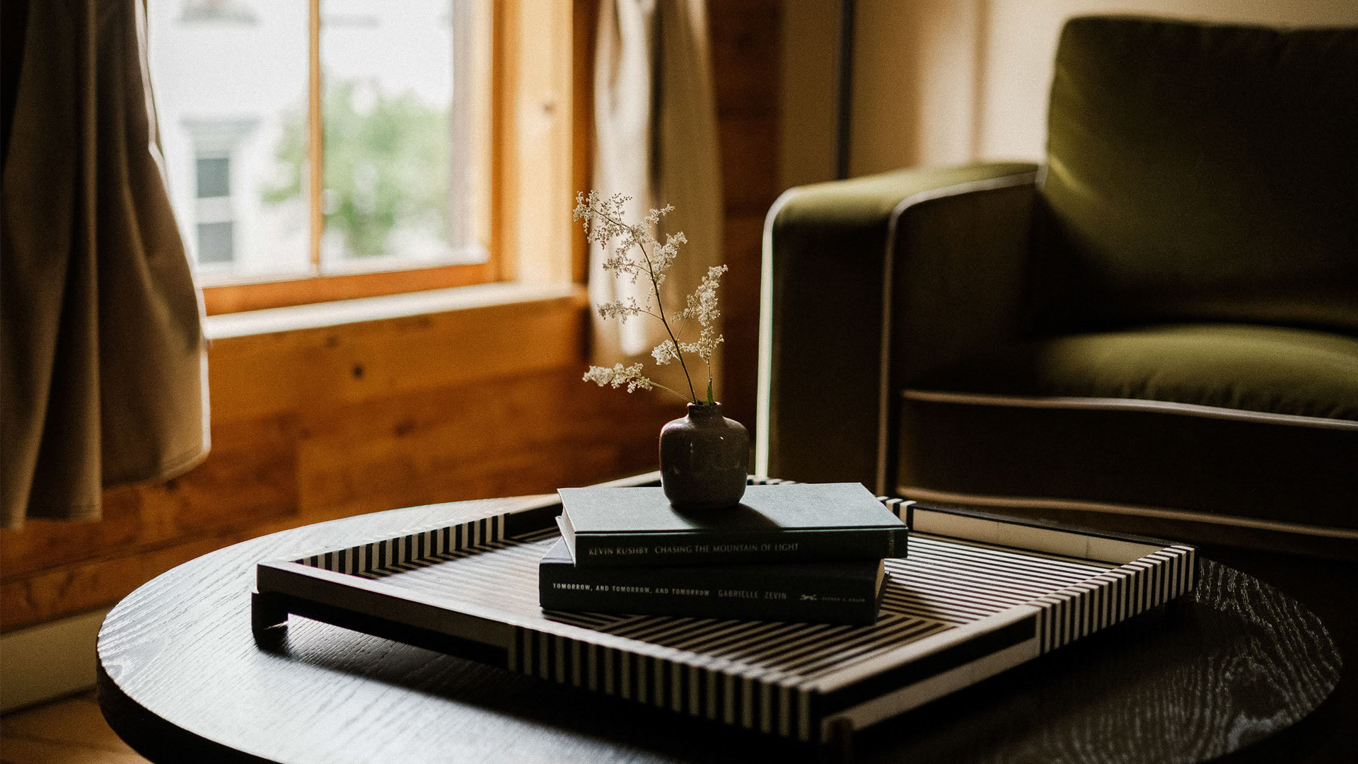 a vase on top of books on a tray