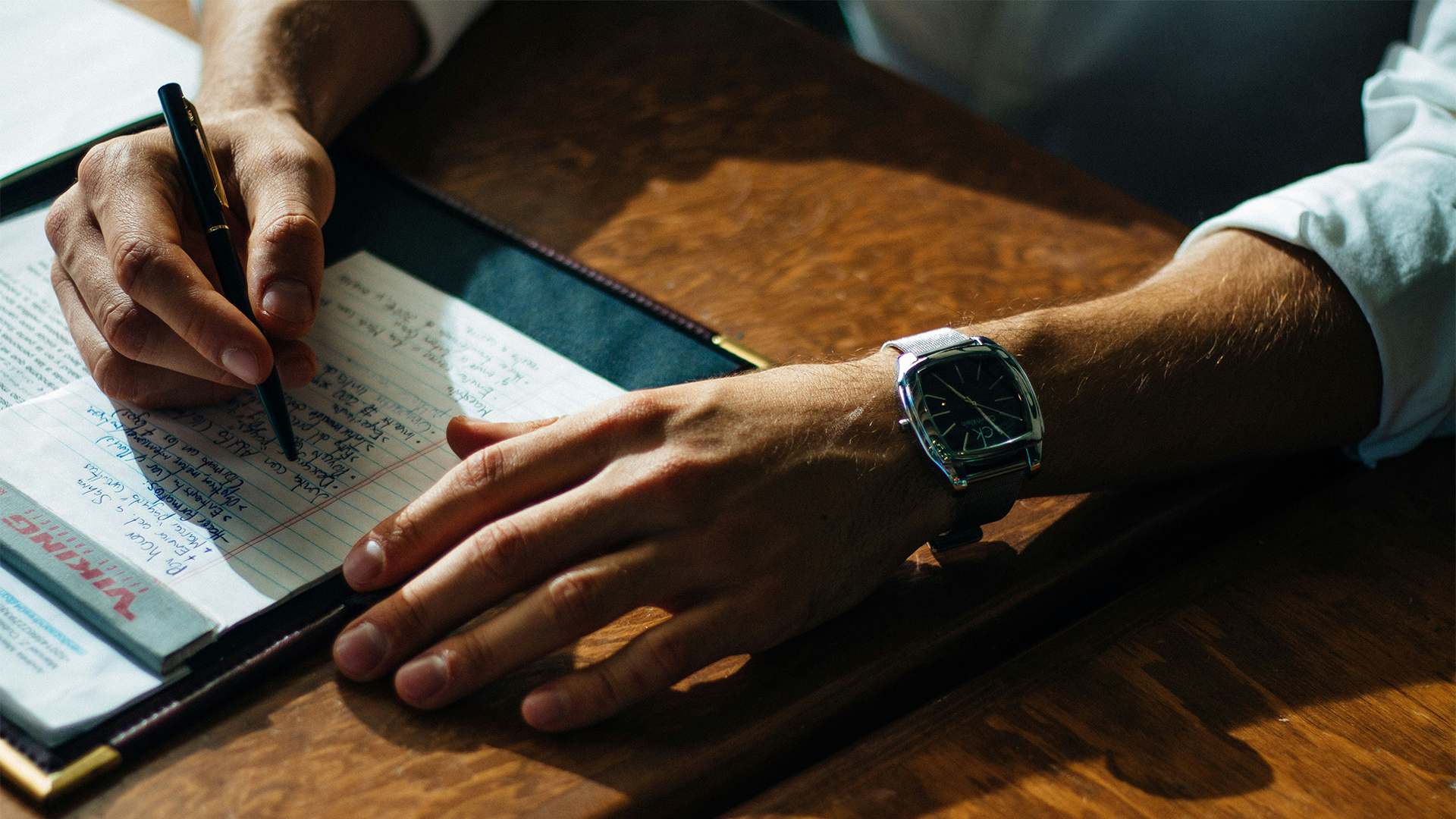 a person's hand with a watch on a table