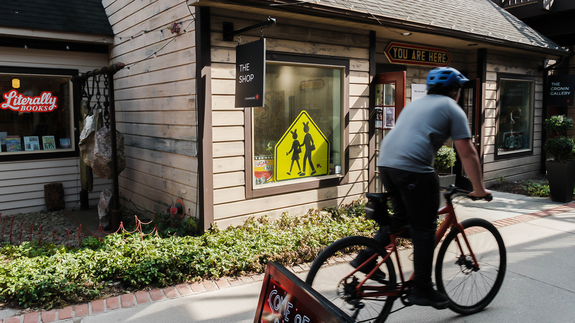 a person riding a bicycle in front of a store