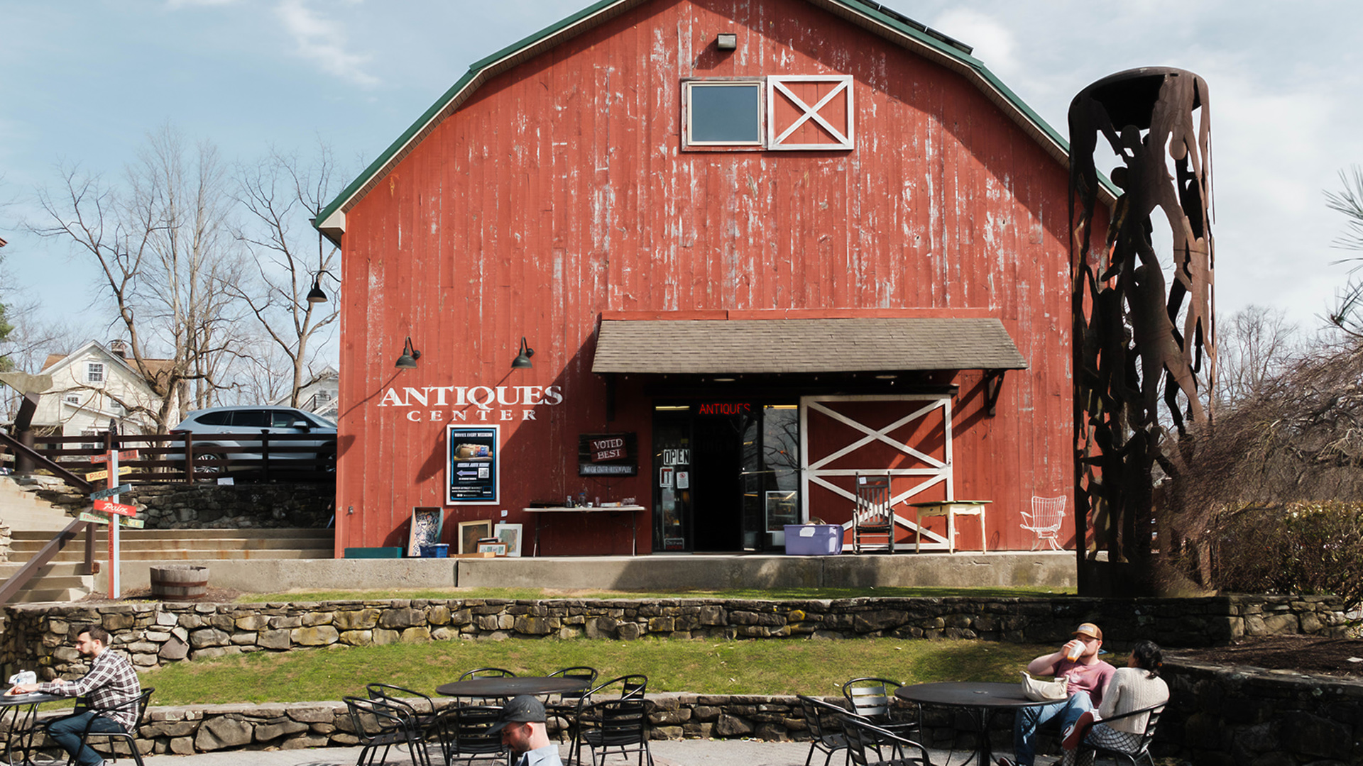 a red barn with people sitting outside