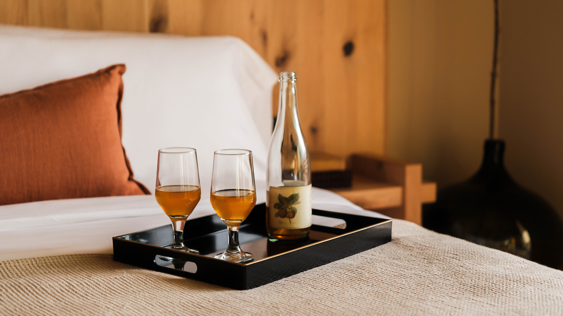 a tray with two glasses and a bottle on it