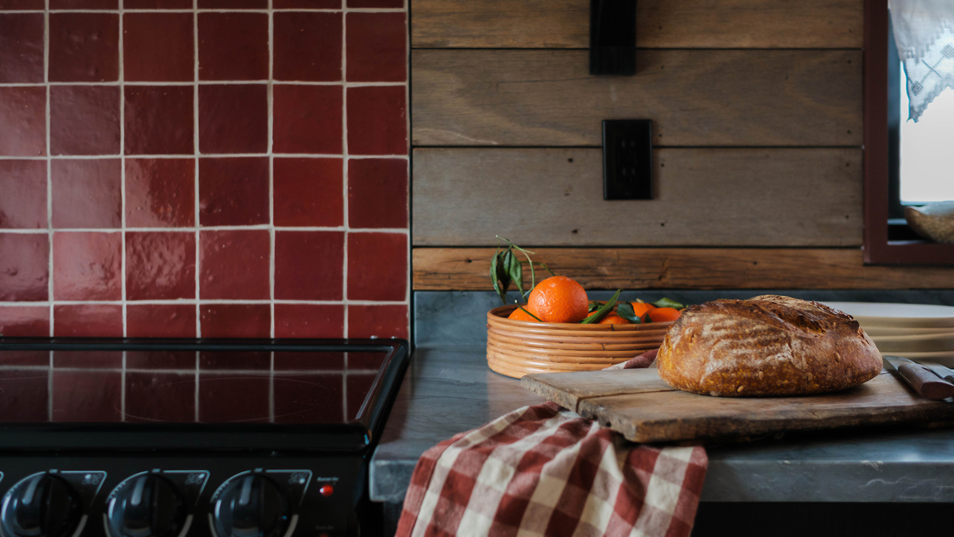a bowl of oranges and bread on a counter