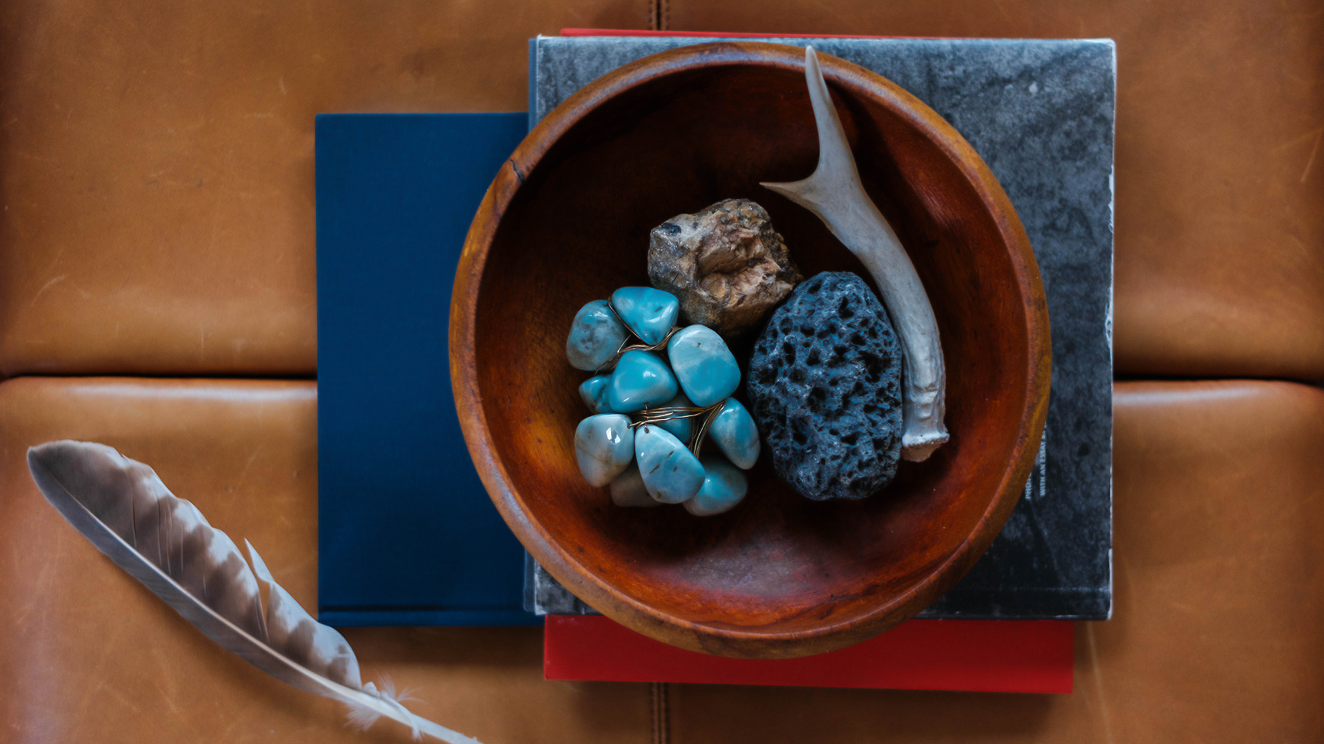 a bowl of rocks and a antler on a stack of books