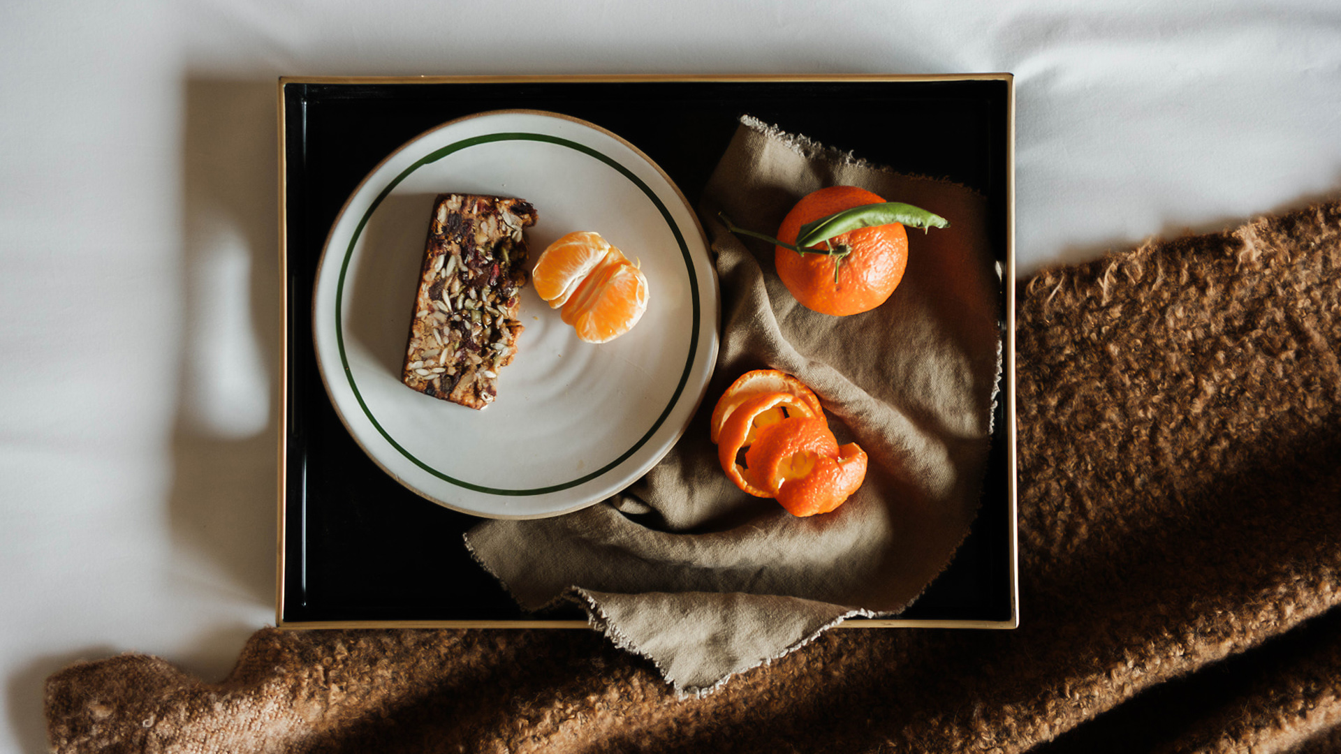 a plate of food and oranges on a blanket