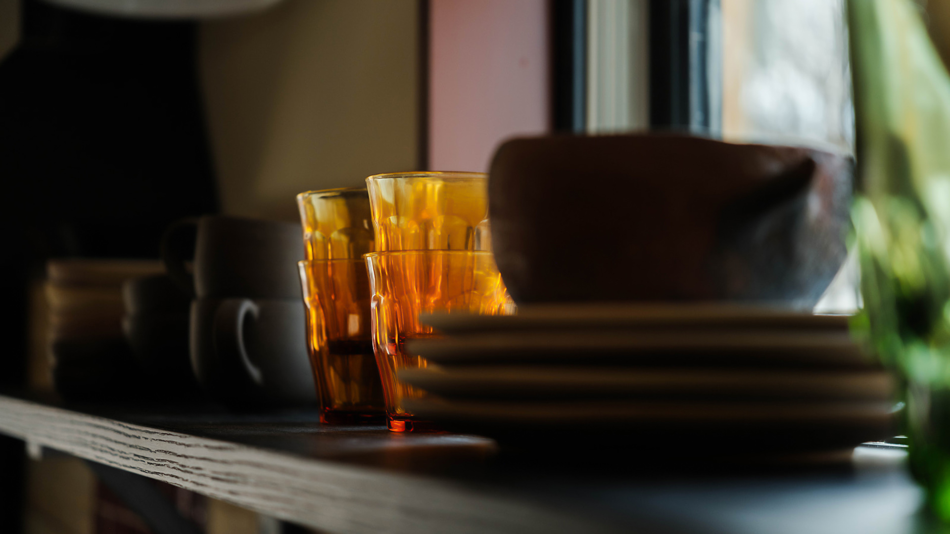 a stack of plates and glasses on a shelf