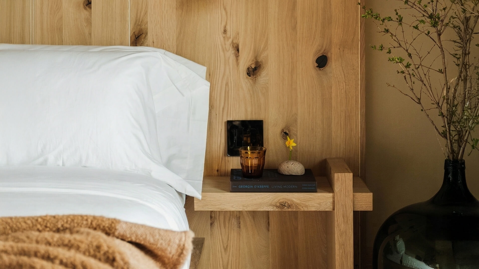 a bed with a candle on a table