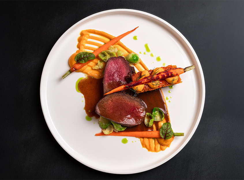 a plate of food on a black surface